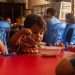 Niño venezolano en albergue comiendo alimentos saludables