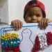 Niño venezolano con arte creada en albergue