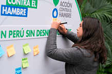 Mujer firmando banner del programa espacios amigables