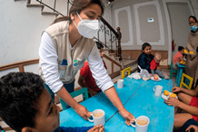 Nutricionista ofreciendo alimentos a niños migrantes en albergue